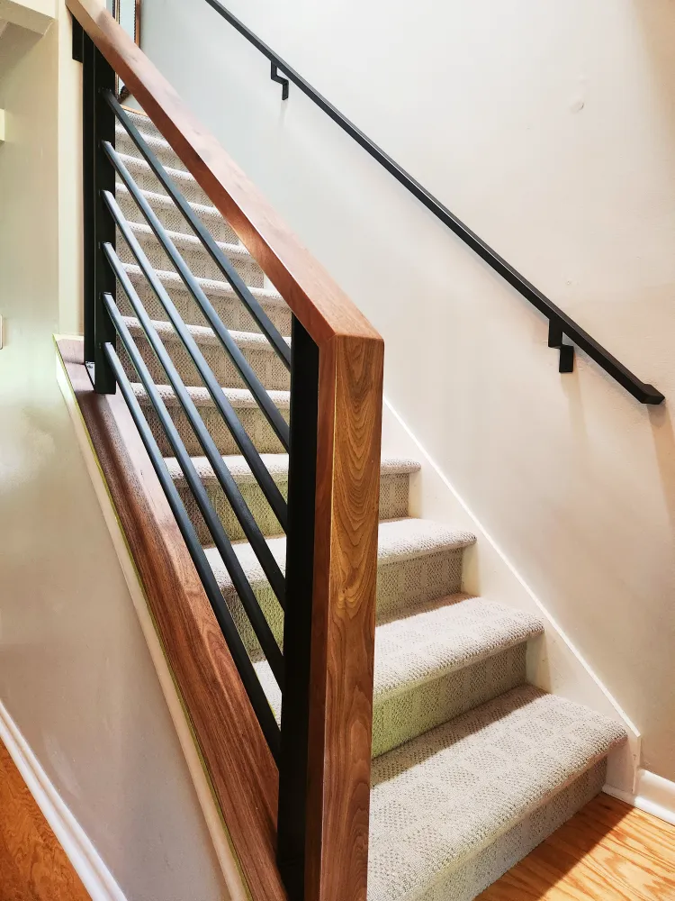 Custom powder-coated interior stair railing with black walnut top railing